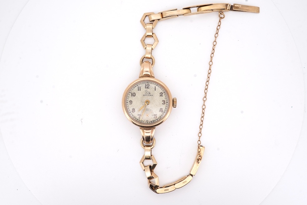 A lady's 9ct gold Record manual wind wrist watch, with Arabic dial and subsidiary seconds, on a 9ct gold bracelet, gross weight 16 grams. Condition - fair